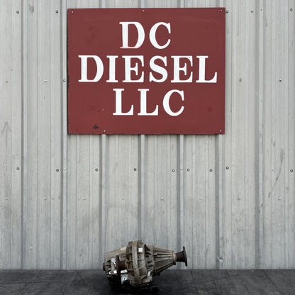 Transfer case displayed in front of a metal building wall with a red sign reading DC Diesel LLC. 03-10 Ford F250 F350 4WD 4X4 Transfer Case NP273 ESOF Auto Shift OEM, suitable for Ford Super Duty trucks with 6.0L Powerstroke engines.