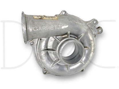 Used OE Garrett turbocharger compressor housing for 99-02 Ford F250 7.3 7.3L Diesel Turbo, showing light wear and good condition, suitable for Ford Powerstroke diesel engine replacement and repair parts.