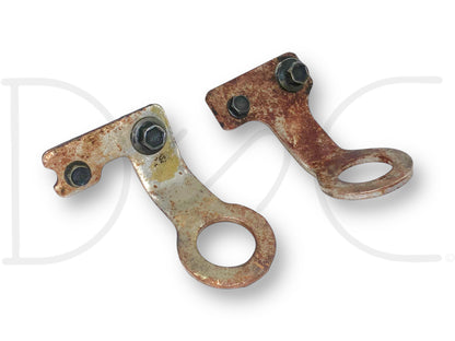 99-02 Ford F250 F350 7.3 7.3L Engine Lifting Eye Bracket Set OEM Brackets Eyes, used with light wear and rust, featuring metal brackets with circular lifting eyes and attached bolts for 1999-2002 Ford Super Duty trucks.
