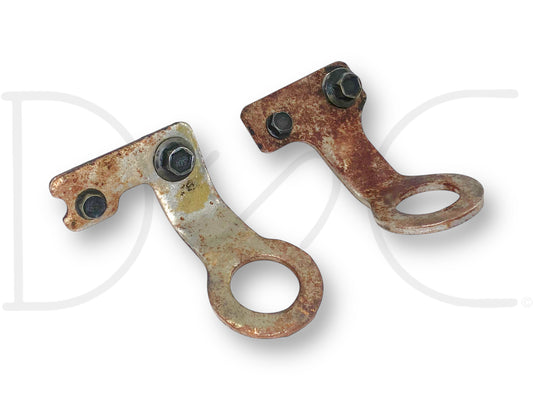 99-02 Ford F250 F350 7.3 7.3L Engine Lifting Eye Bracket Set OEM Brackets Eyes, used with light wear and rust, featuring metal brackets with circular lifting eyes and attached bolts for 1999-2002 Ford Super Duty trucks.