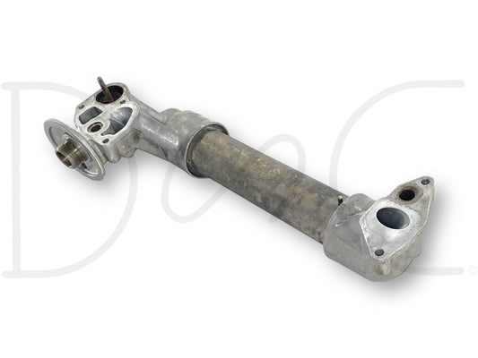 Used metal oil cooler assembly with aftermarket tube and OEM caps, showing light wear and suitable for diesel engine cooling, specifically the 99-02 Ford F250 F350 7.3 7.3L Powerstroke Diesel Oil Cooler Assembly 1815739C2.