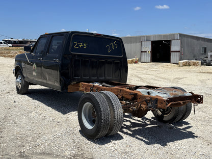 92-97 Ford F250 F350 Front Fender LH Left Driver Ua Black installed on a used black Ford truck chassis with dual rear wheels, showing light wear and rust on rear frame.